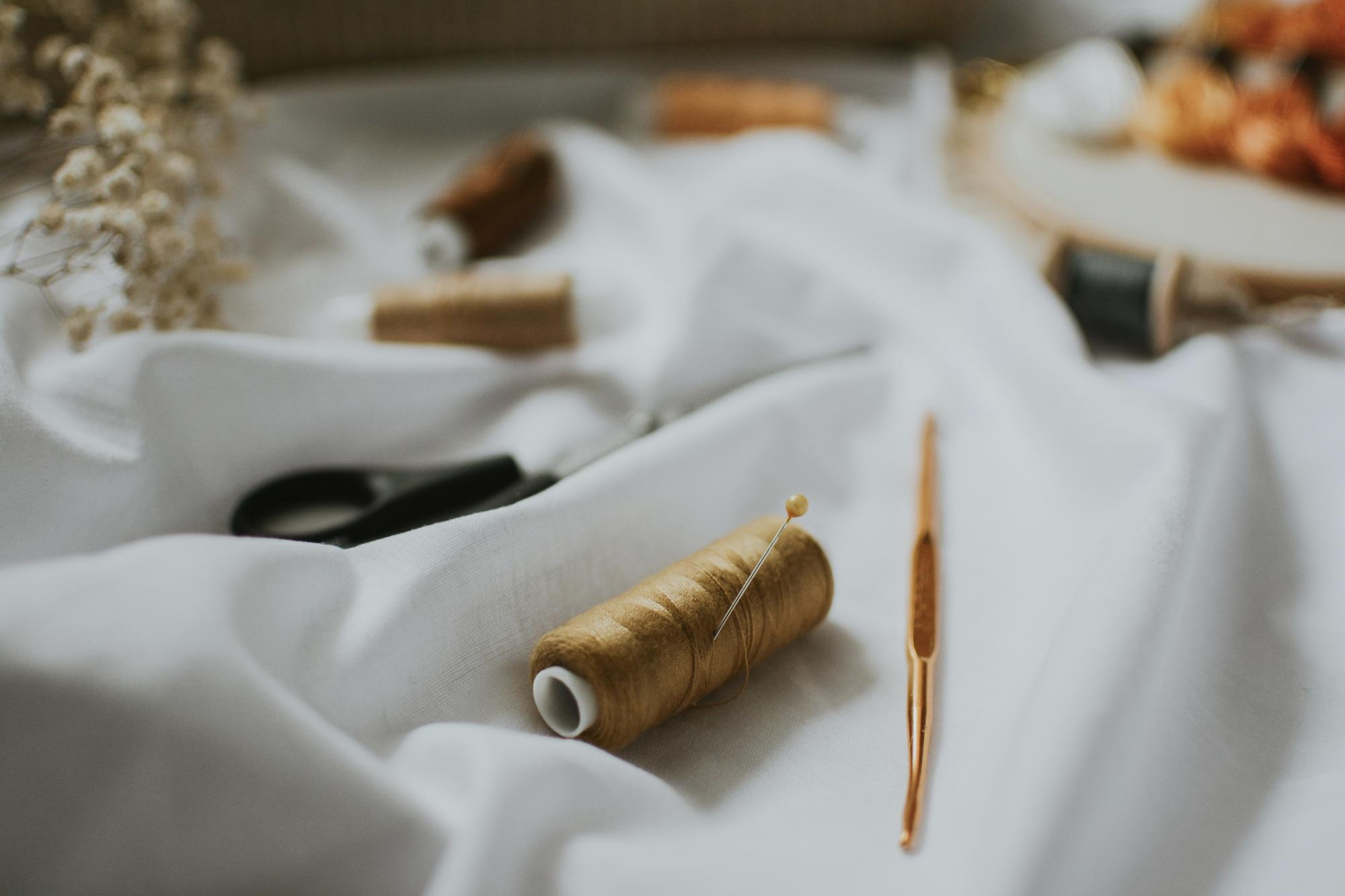 atelier needle and thread over linen fabric